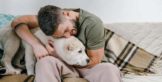 Mann kuschelt mit seinem Hund